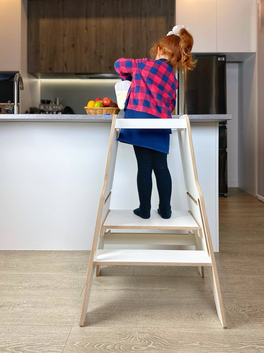Child engaging with the Plywood Learning Tower, highlighting its secure, adjustable design and kid-friendly features for safe kitchen exploration.