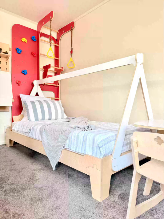 Cozy kids’ bedroom with a birch plywood Flippable Bed and canopy frame, creating a calm Montessori-style sleep space.