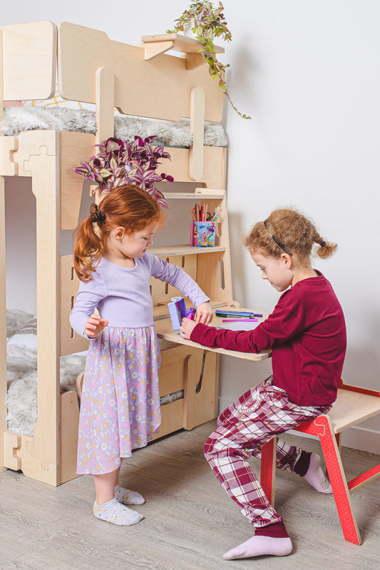Kids drawing and playing beside an eco-friendly wooden bunk bed with built-in desk in a minimalist NZ bedroom