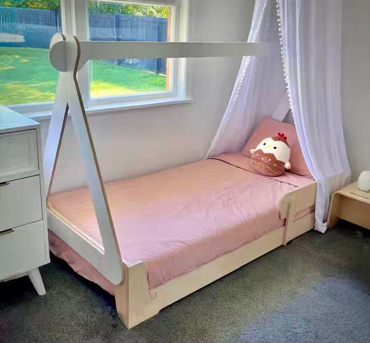 Cozy Montessori-style floor bed with a canopy frame in a calm kids’ bedroom, creating a safe, low sleep space for independent bedtime routines