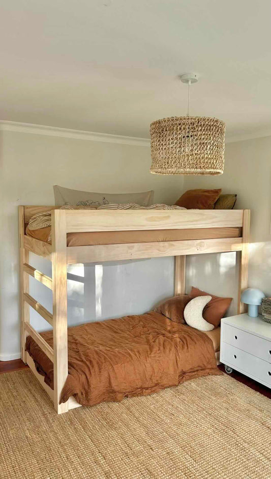 Bunk bed made from natural New Zealand pine in a cozy children’s bedroom with warm decor.