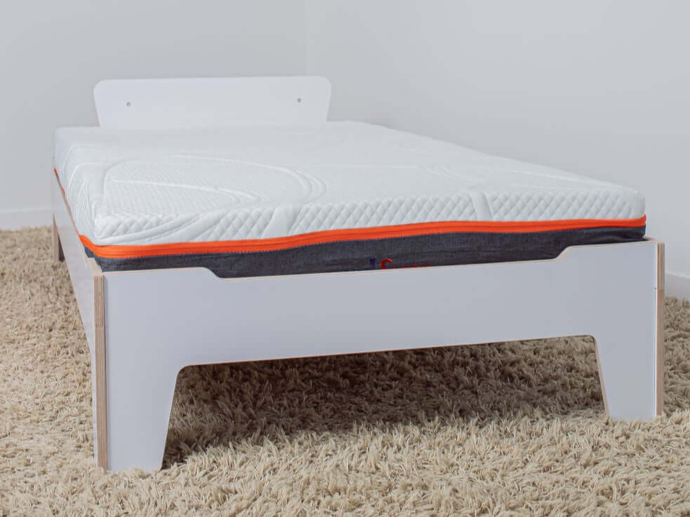 Flippable wooden bed frame with a two-sided waterproof mattress, designed to grow with your child