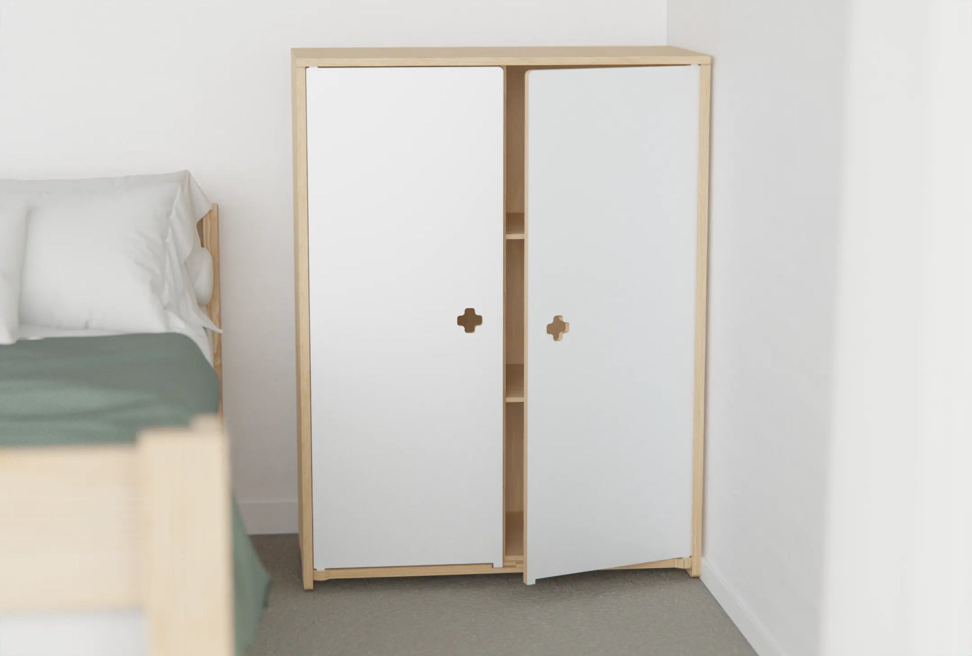 Birch plywood kids’ cupboard with white doors and soft cut-out handles, hiding toys and books for a clutter-free room
